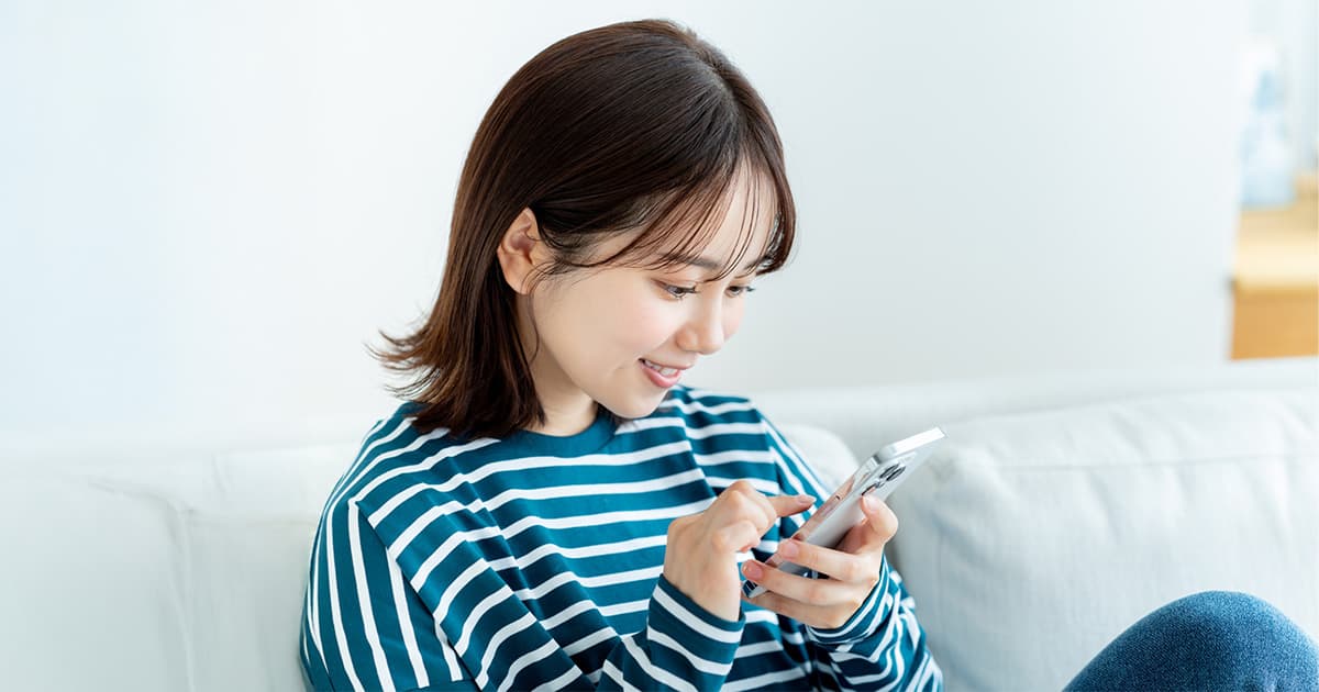 部屋でスマートフォンを見ている