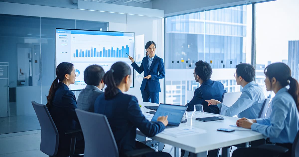 会議室でホワイトボードで説明中